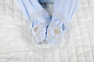 Closeup of a baby wearing rompers body in bed