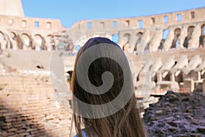 Closeup back view of female tourist inside Colosseum in Rome, Italy.