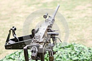 Closeup and back view of M2 .50cal Browning machine gun with tripod standing in bunker photo