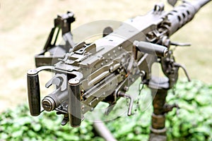 Closeup and back view of M2 .50cal Browning machine gun with tripod standing in bunker