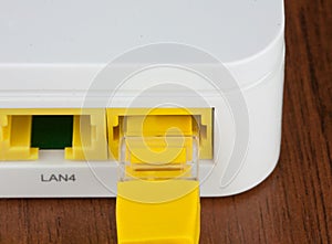 Closeup back of white wifi router LAN port with UTP patch cord inside