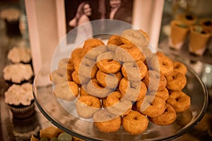 Closeup of baked mini donuts on a tray on the table during an event