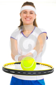 Closeup on ball on racket in hand of tennis player