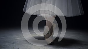 Ballerina legs dancing on tiptoe. Ballet dancer feet performing in pointe shoes.