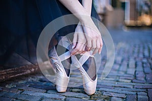 Closeup of ballerina`s feet in pointe on street. Strong fit ballerina`s legs