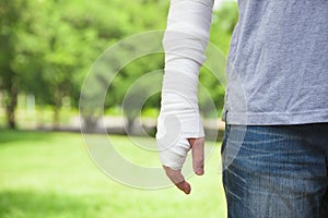 Closeup of bandaged arm with park background