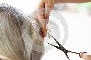 Closeup barber with Scissors cutting hair