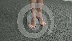 Closeup of barefoot female legs exercising on medicine ball