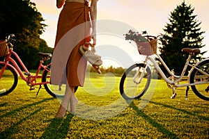 Closeup barefoot young female bicyclist on park grass lawn