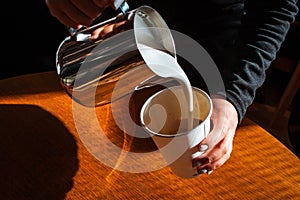 Closeup of the barista's hand making coffee in a plastic cup
