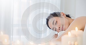 Closeup beautiful asian young  woman lying down on massage beds at Asian luxury spa and wellness center.