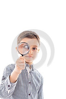 Closeup of a beautiful child looking through a magnifying glass