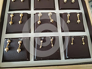 Closeup of beautiful designed Golden Ear Rings arranged in a box at Local Jewellery Shop