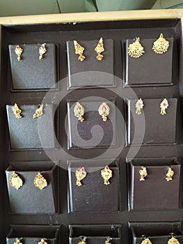 Closeup of beautiful designed Golden Ear Rings arranged in a box at Local Jewellery Shop