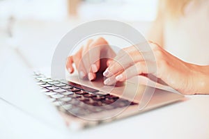 Closeup beautiful female hands typing on keyboard using a laptop in a cafe ,successful business woman,working,,blurred background