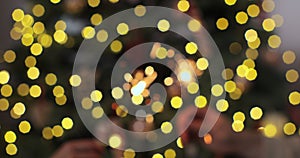 Closeup of beautiful female and man hands holding two stick of holiday sparkler burning isolated at blurry Christmas