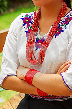 Closeup beautiful hispanic woman wearing traditional andean white blouse with colorful decoration around neck, matching