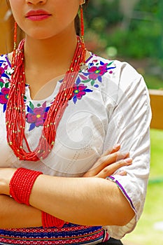 Closeup beautiful hispanic woman wearing traditional andean white blouse with colorful decoration around neck, matching