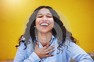 Closeup beautiful mixed race fashion woman smiling with a big smile against a yellow wall background in the city. Young