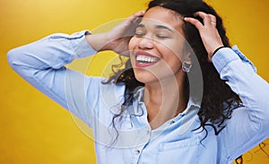 Closeup beautiful mixed race fashion woman smiling with her eyes closed against a yellow wall background in the city