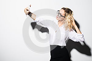 Closeup of beautiful playful business woman making selfie on isolated white background