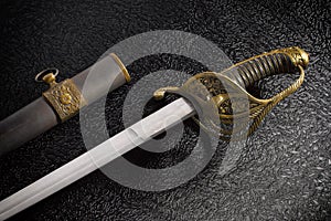 Closeup of a beautiful sword saber with scabbards against a dark