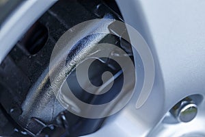 Closeup of beautiful wheel of expensive supercar having black painted break callipers and large disc brake photo