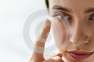 Closeup Of Beautiful Woman Applying Eye Lens In Eye