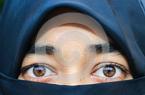 Closeup of beautiful woman face covered with hijab. Perfect shiny eyes of a Muslim girl. Young niqab girl portrait.