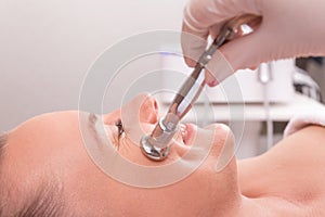 Woman while procedure jet peeling, facial treatmen