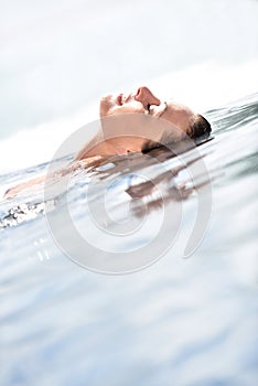 Closeup of beautiful woman relaxing in the pool