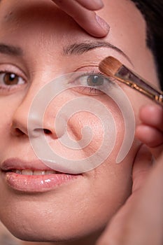 Closeup Of Beautiful Young Woman Face With Beauty Makeup, Fresh Soft Skin And Long Black Thick Eyelashes Applying