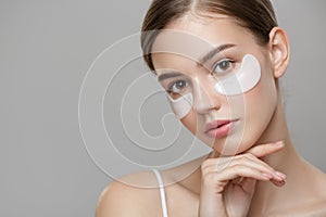 Closeup Of Beautiful Young Woman Face With Natural Makeup, Healthy Fresh Skin And Collagen Hydrogel Eye Patches