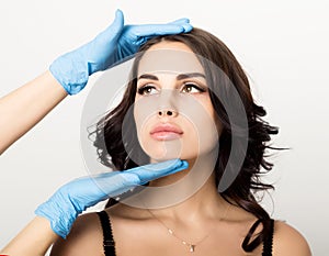 Closeup of Beautiful young woman gets injection in eye and lips area from beautician. cosmetology concept photo