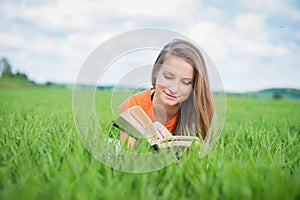 Closeup of a beautiful young woman reading book at park