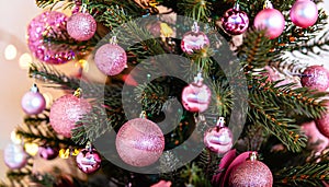 Closeup of a beautifully decorated Christmas tree with sparkly pink decorations and lights