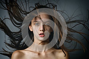 Closeup beauty portrait of a brunette girl with flying hair