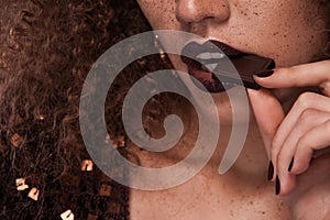 Closeup beauty portrait of young african american girl with afro hairstyle and chocolate . Girl posing on brown