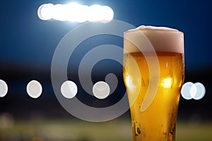 closeup beer, blurred stadium lights at night