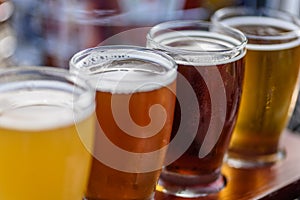 Closeup of a beer flight on wood paddle outside in sunlight