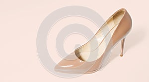 Closeup beige women patent leather shoe  on pink background. Stilettos shoe type. Summer fashion and shopping concept.