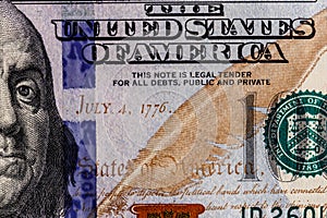 Closeup of Ben Franklin and the date of independence July 4, 1776 on a one hundred dollar bill for background VII