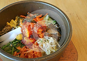 Closeup Bibimbap or Korean Traditional Mixed Rice with Meat and Assorted Vegetables in Hot Stone Bowl