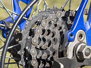 Closeup of a bicycle gears mechanism and chain on the rear wheel of mountain bike. Dirty rear cassette with stars in oil and dust