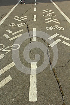 Bicycle lane demarcation with huge crack in asphalt photo