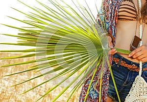 Closeup on big green tropical leaf in hand of bohemian chic