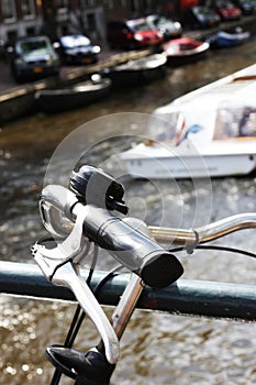 Closeup of bike handles with tour boat passing behind.