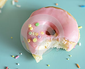 Closeup of bitten donut on light blue background