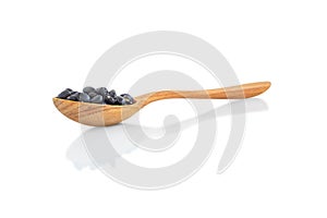 Closeup black beans seeds in wooden bowl on white background, healthy food concept