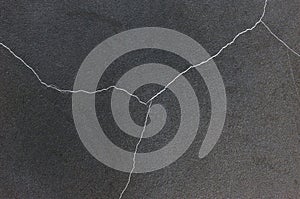 Closeup black concrete wall crack.